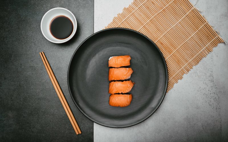 japanese-salmon-nigiri-rice-sushi-presented-top-black-plate-with-soy-sauce-chopsticks