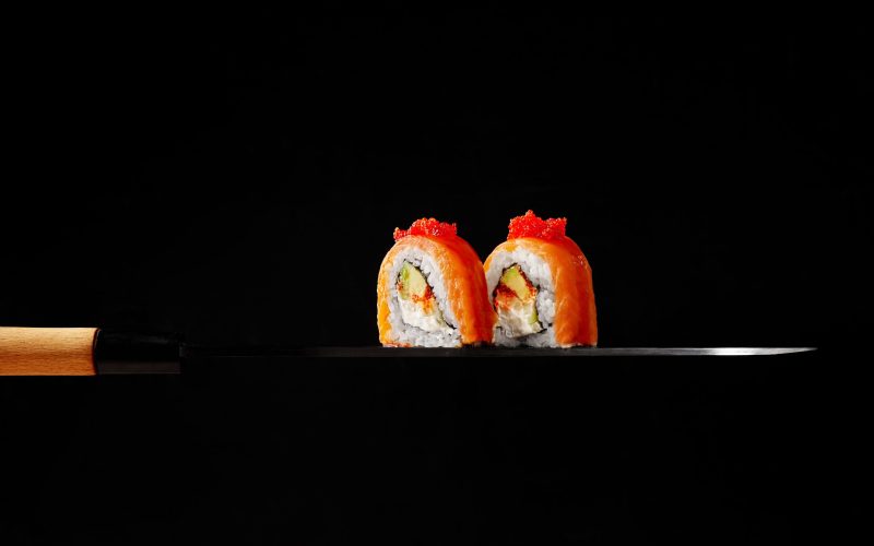 two-philadelphia-rolls-with-smoked-salmon-cream-cheese-avocado-tobiko-blade-sashimi-knife