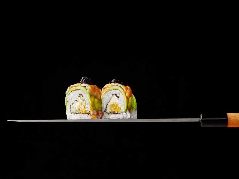 two-uramaki-rolls-with-cream-cheese-mango-avocado-shrimps-blade-japanese-knife-black-ba